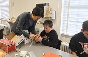 Emily Kang, PhD, associate professor in Adelphi University’s College of Education and Health Sciences, lends a hand in Adelphi’s STEAM Lab, a community makerspace where faculty and students work with local K-12 students.