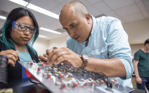 California State University San Marcos Physics Professor Justin Perron and student Josefa Gregorio work together to assemble a panel in a experimental condensed matter physics laboratory.
