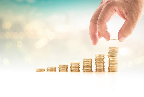 endowment Photo of a hand stacking coins in a row