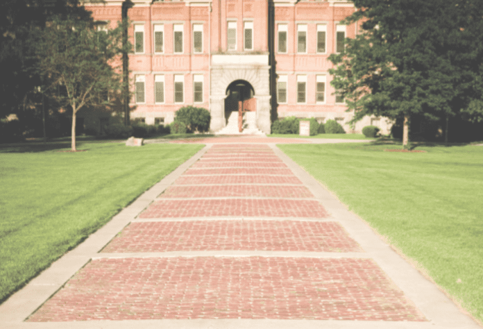 Spring Semester Lead Photo of a brick pathway leading to a building on a college campus.