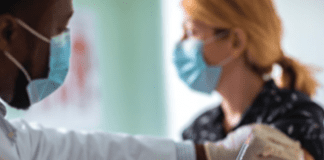 Photo of a medical professional administering a COVID-19 vaccine to a patient.