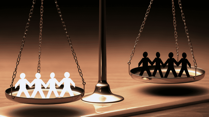 racism Photo of a scale depicting White stick figures on one side and Black stick figures on the other side.