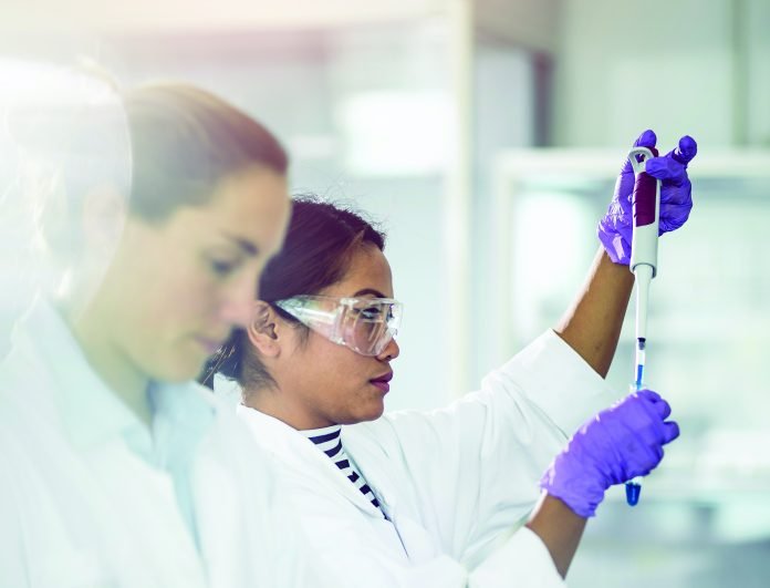 Scientist Pipetting Into a Test Tube