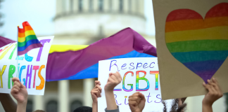 Photo of a group of protestors holding signs demanding LGBTQ rights.