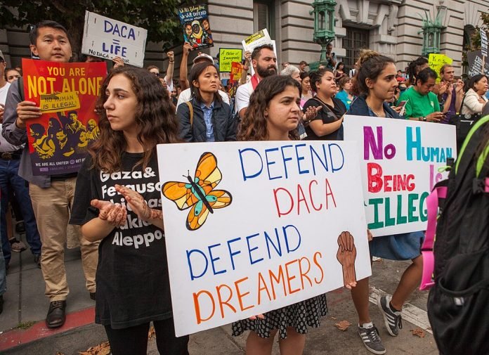 1024px-DACA_rally_SF_20170905-8471 Protesters hold various signs and banners at a DACA rally in San Francisco. Photo by Wikipedia user Pax Ahimsa Gethen