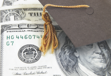Photo of a mortarboard hat placed on top of a U.S. one hundred dollar bill