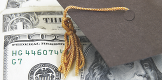 Photo of a mortarboard hat placed on top of a U.S. one hundred dollar bill