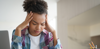 Black female college student resting her heads in her hands