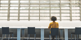 Black woman sits alone at a table