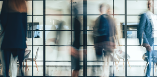 blurred photo of people walking in an office