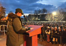Michigan State University student Joseph Kesto stands at a podium in front of a crowd