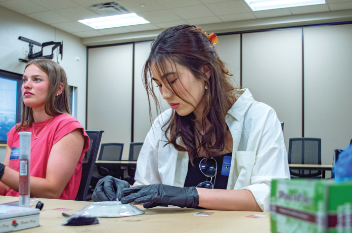 uwwicj1 Students participate in a fingerprinting activity during a UW-Women in Criminal Justice Mentoring Program event at the Madison Police Department. (Photo courtesy of the UW-Women in Criminal Justice Mentoring Program)