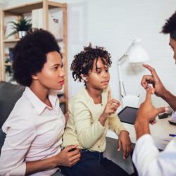 Photo of an African American man, woman, and child using sign language